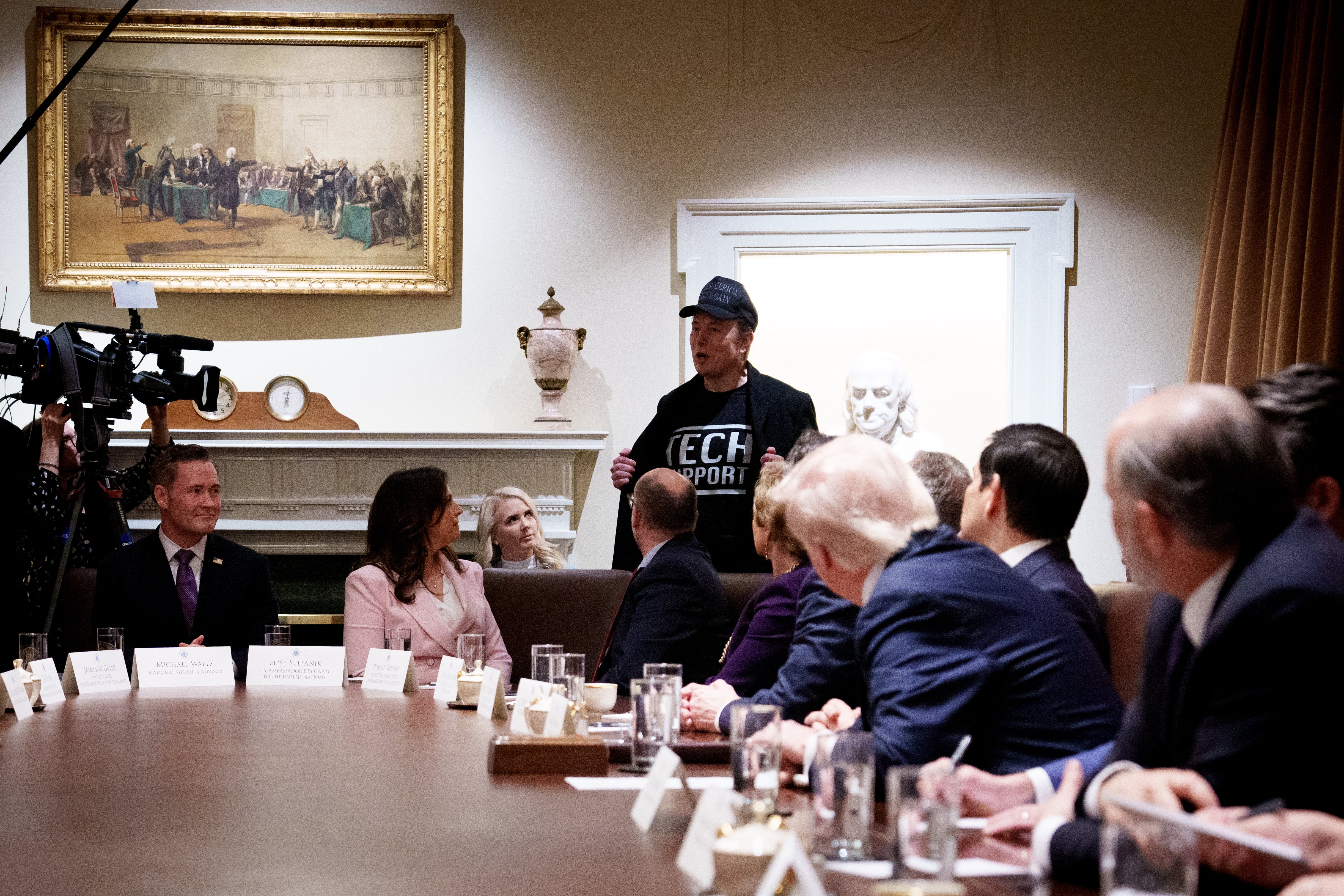 WASHINGTON, DC - FEBRUARY 26: Tesla and SpaceX CEO Elon Musk, head of the Department of Government Efficiency (DOGE), displays his t-shirt that reads "Tech Support" as he speaks during a Cabinet meeting held by U.S. President Donald Trump at the White House on 25 February  2025 in Washington, DC. Trump is holding the first Cabinet meeting of his second term.