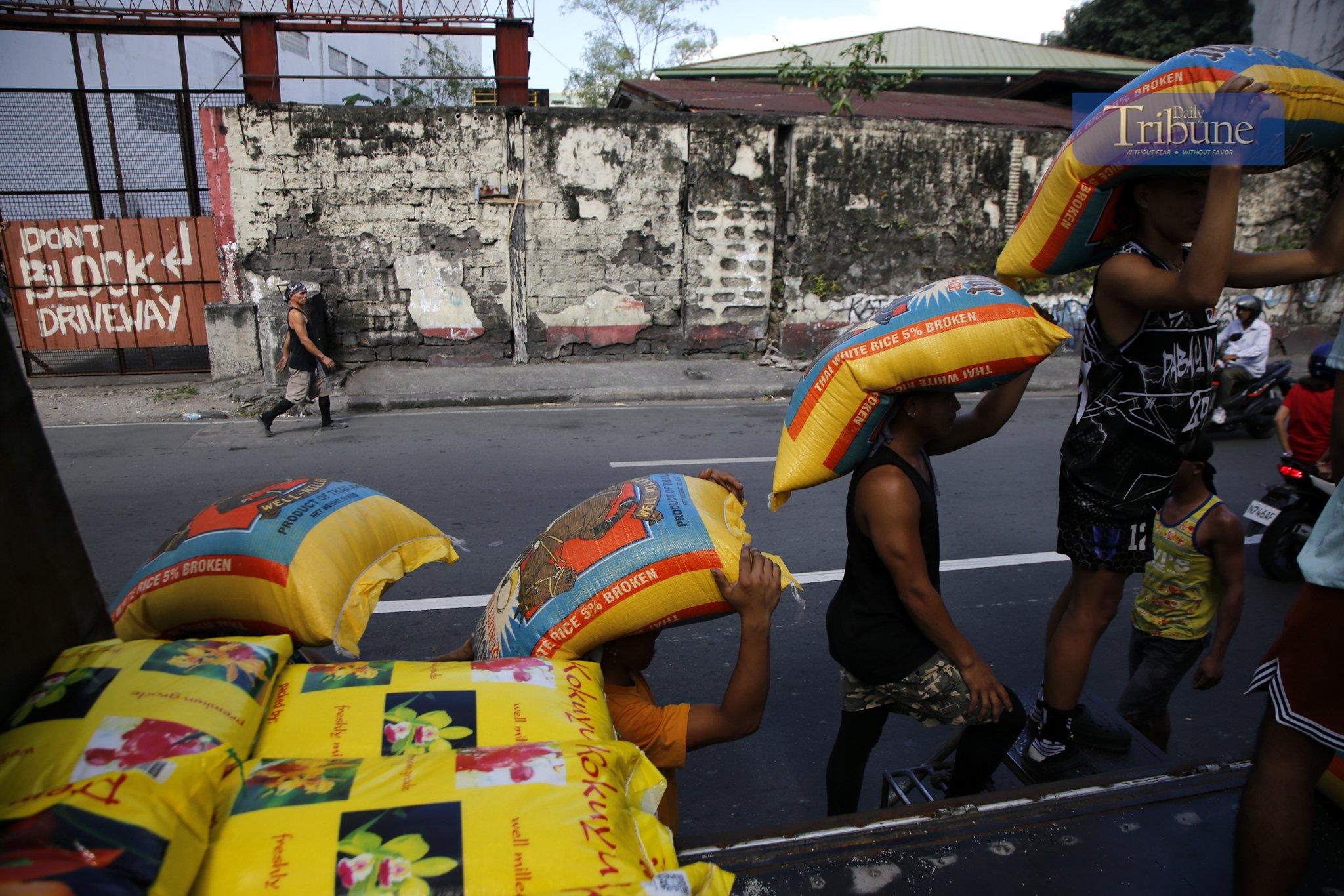 Workers load imported rice sacks onto a truck in Manila