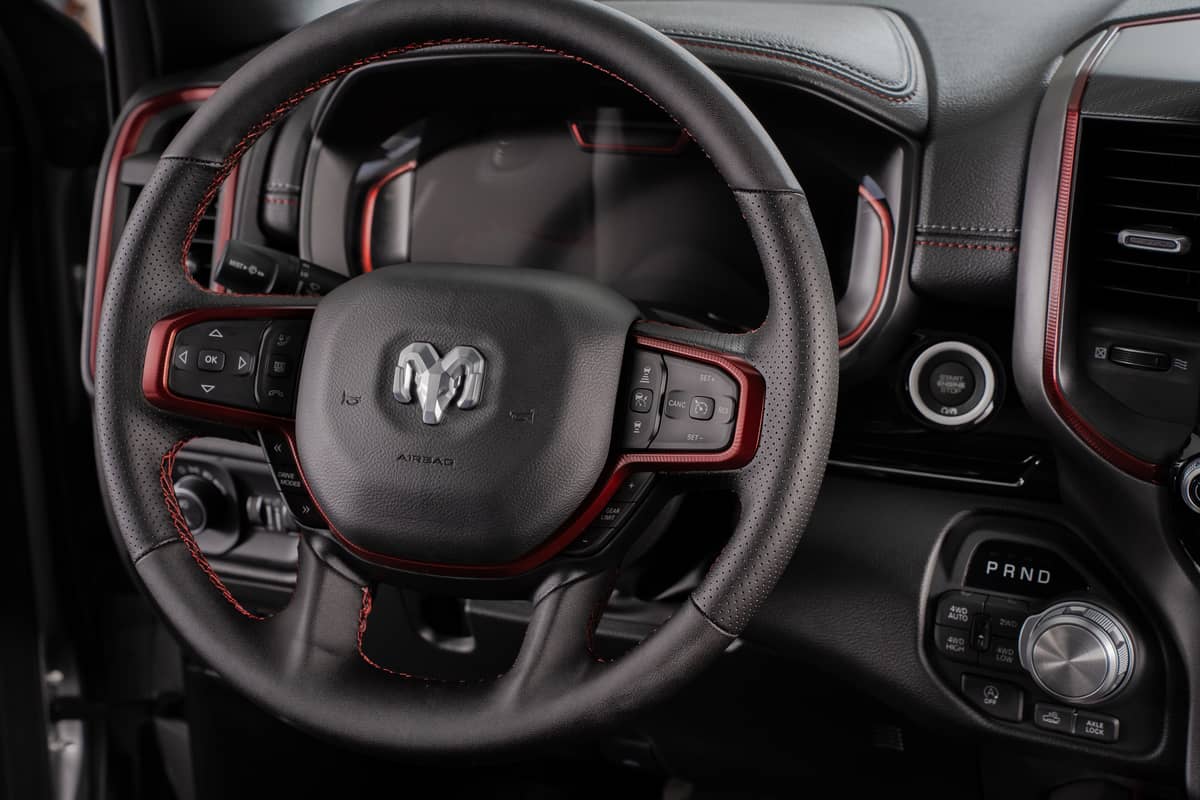 The cockpit of the Ram 1500 Rebel has easy-to-use controls and a leather-wrapped steering wheel with red accents.