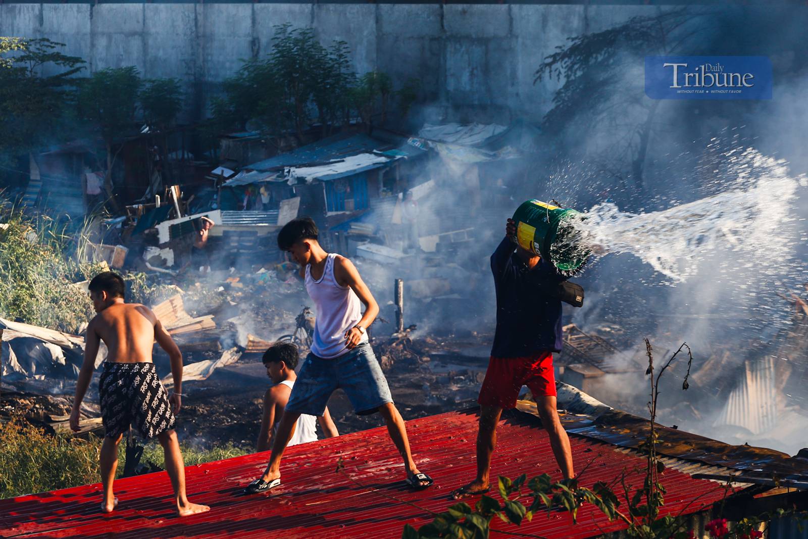 Residents and firefighters extinguish a fire that hit a residential community in Barangay Ususan, Taguig City, on the 4th day of Fire Prevention Month, 4 March 2025. The fire, which prompted the raising of the 4th alarm at 2:45 PM, was declared under control at 3:27 PM.