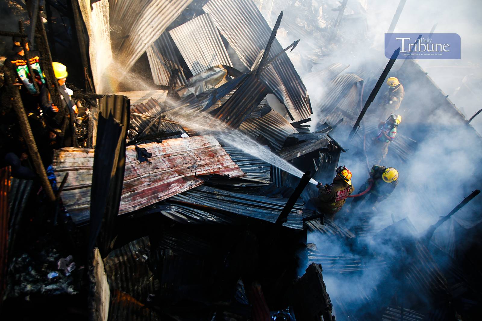 Residents and firefighters extinguish a fire that hit a residential community in Barangay Ususan, Taguig City, on the 4th day of Fire Prevention Month, 4 March 2025. The fire, which prompted the raising of the 4th alarm at 2:45 PM, was declared under control at 3:27 PM.