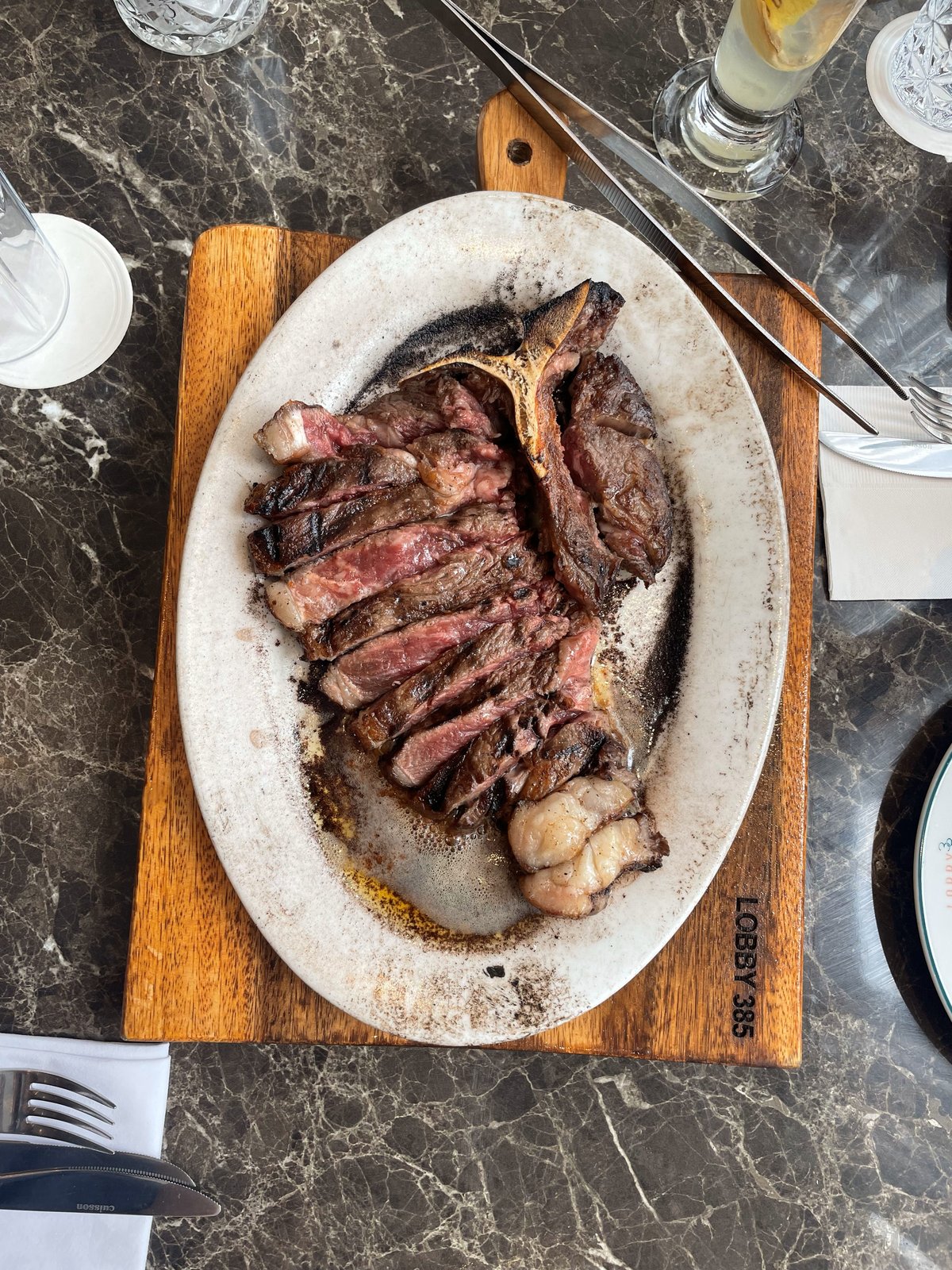 Twenty-eight-day dry-aged T-bone steak made from hybrid Wagyu and Angus beef, served medium rare with a hot stone to achieve your own personal desired doneness.