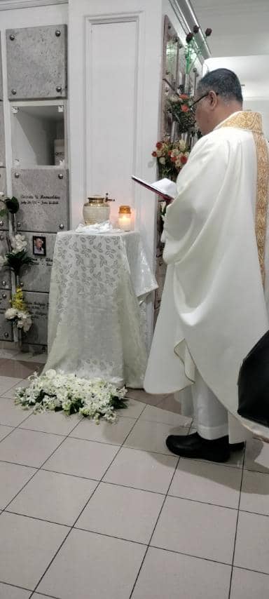 Father John sison blesses Glorias final resting place.