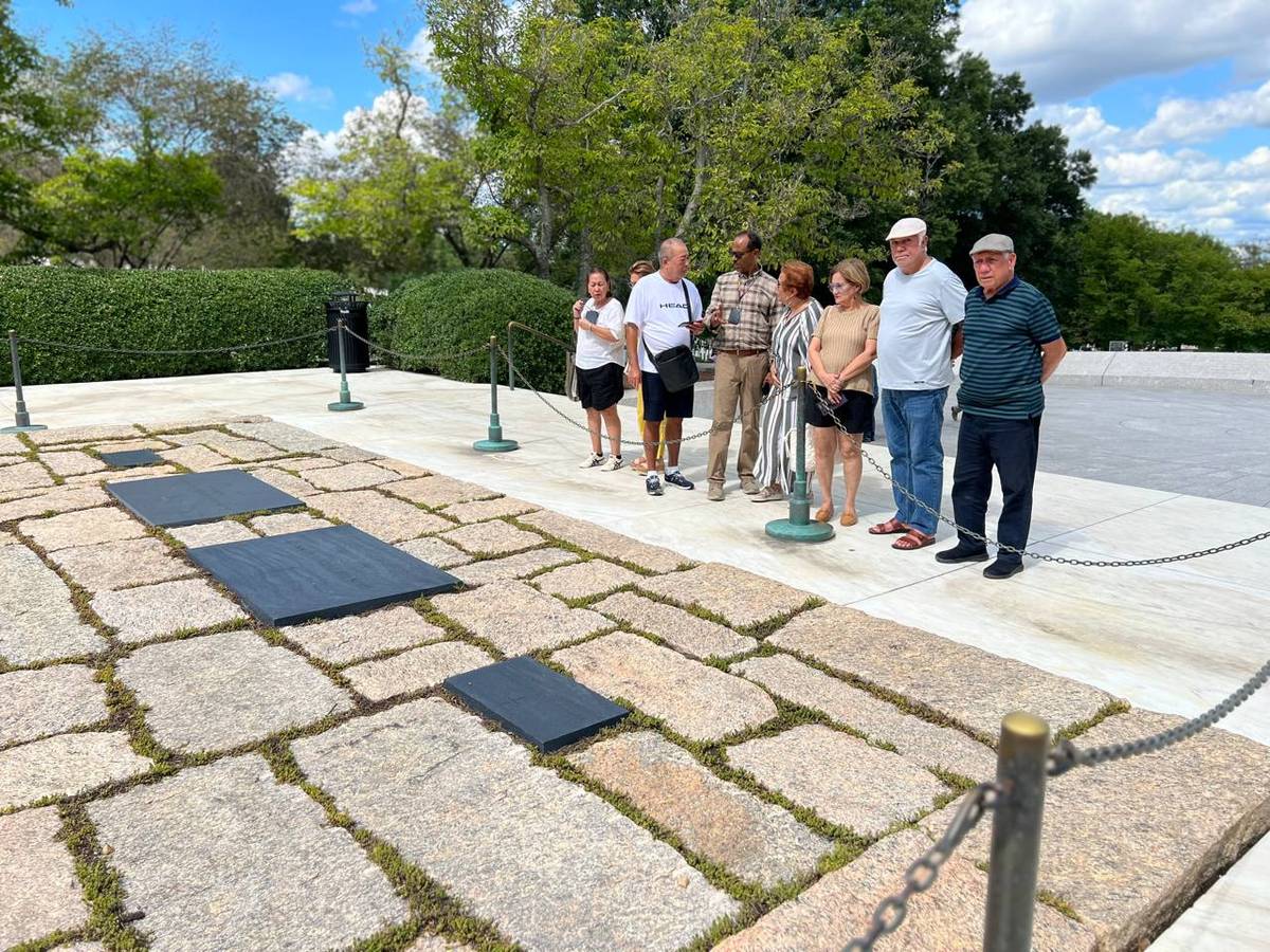 Tourists reflect on the gravesite of the Kennedys.