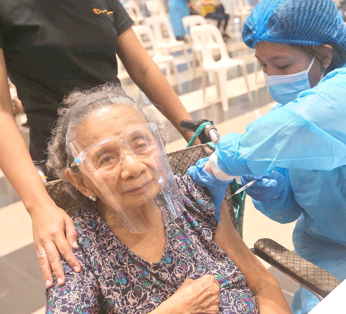 Lady health worker administers booster shot to a patient.