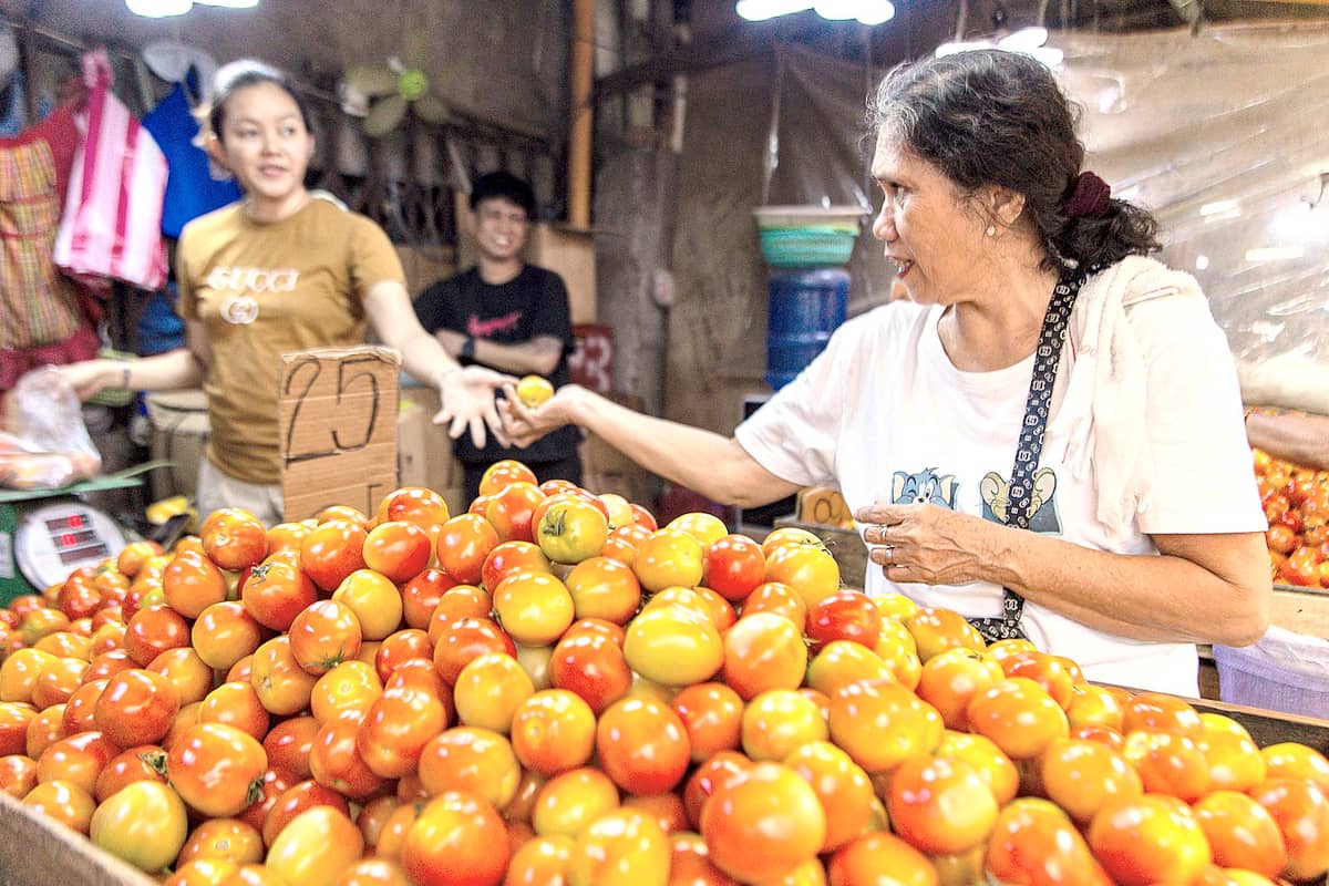 A mother skillfully stretches her budget for fresh produce and staples through sharp haggling and warm vendor chats.