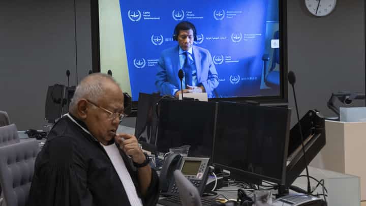 (FILE PHOTO) Former Philippine President Rodrigo Duterte is seen on a screen with his lawyer Salvador Medialdea (L) in the courtroom during his first appearance before the International Criminal Court (ICC) on charge of crimes against humanity over his deadly crackdown on narcotics, in The Hague on 14 March 2025. The 79-year-old, the first ex-Asian head of state to face charges at the ICC, followed by videolink during a short hearing to inform him of the crimes he is alleged to have committed, as well as his rights as a defendant. Duterte stands accused of the crime against humanity of murder over his years-long campaign against drug users and dealers that rights groups said killed thousands.