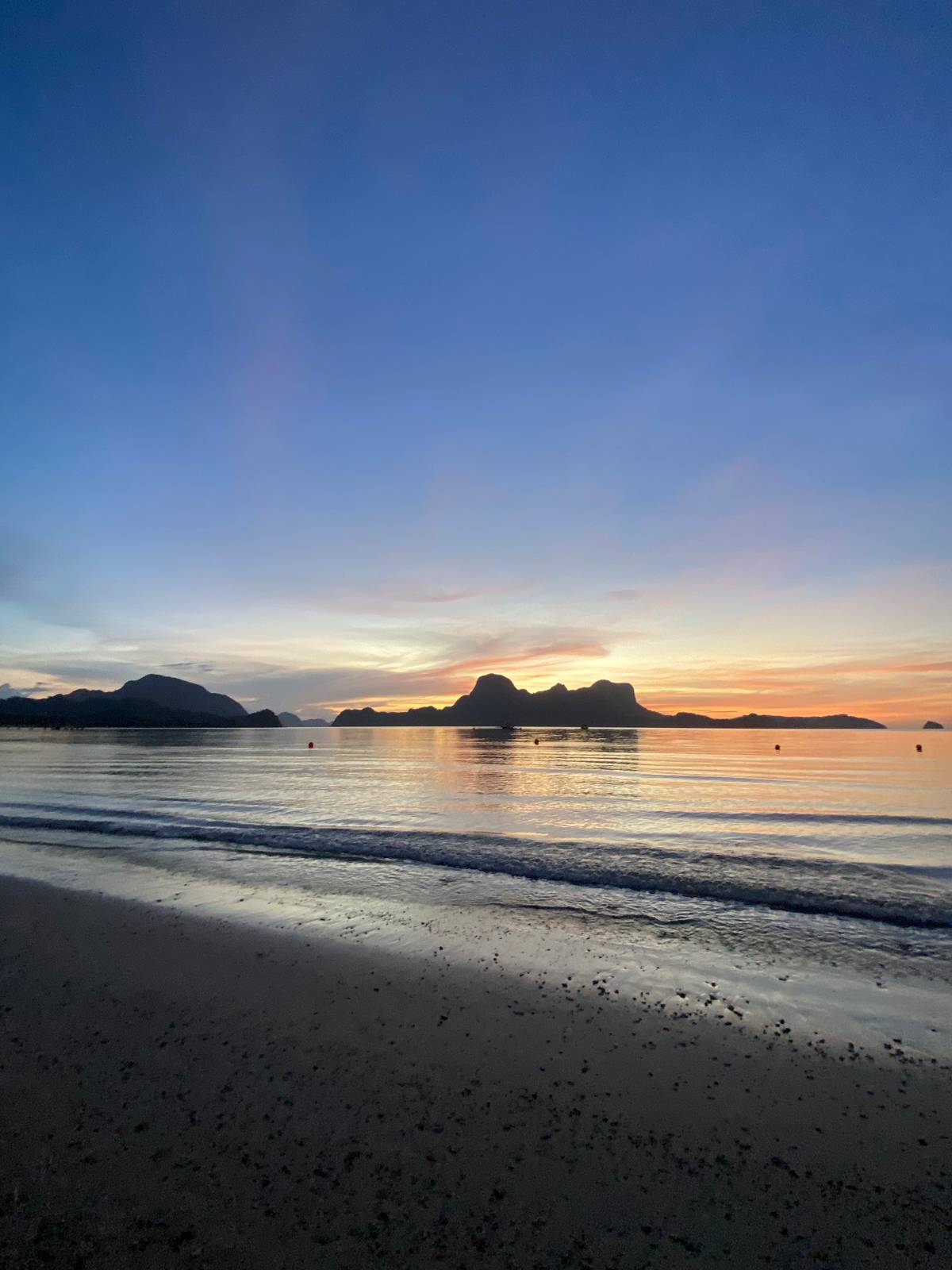 Golden hues paint the sky as the sun sets over El Nido’s serene shores, offering a moment of pure tranquility.