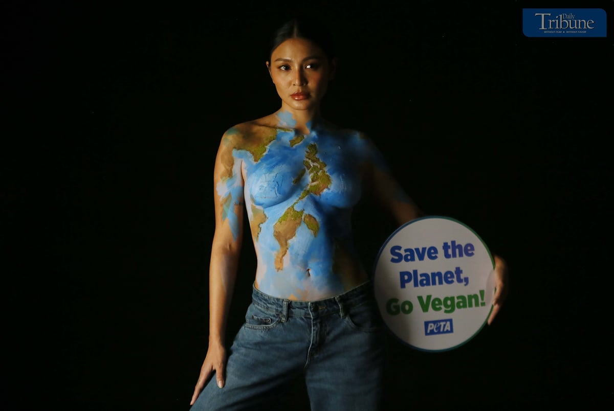 Actress and singer Nadine Lustre, wearing only body paint, holds a "Save the Planet, Go Vegan" sign while posing as Mother Earth during a photo shoot in Pasig City on 17 March  2025. Lustre promotes the vegan lifestyle as part of a campaign by People for the Ethical Treatment of Animals (PETA).