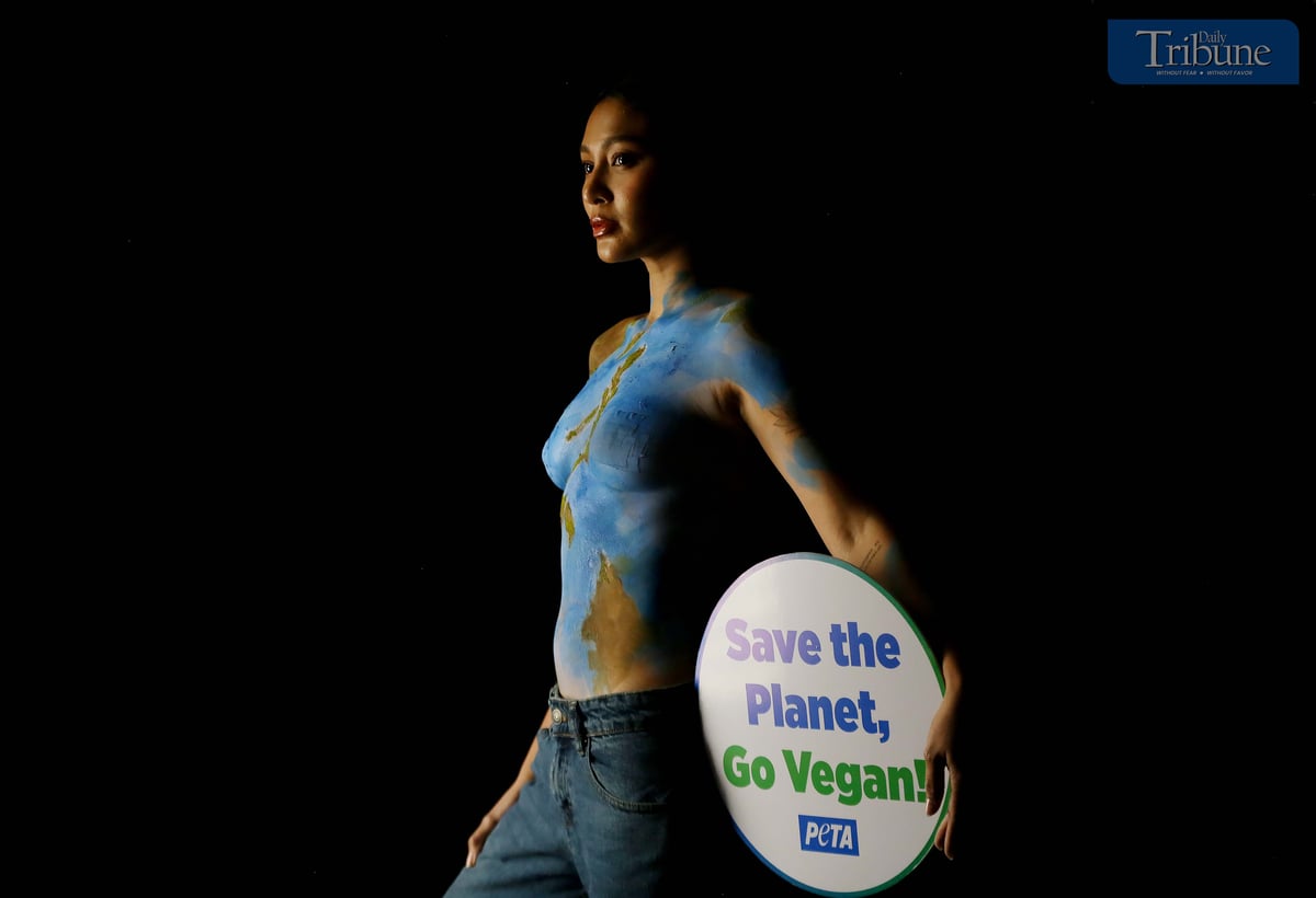 Actress and singer Nadine Lustre, wearing only body paint, holds a "Save the Planet, Go Vegan" sign while posing as Mother Earth during a photo shoot in Pasig City on 17 March  2025. Lustre promotes the vegan lifestyle as part of a campaign by People for the Ethical Treatment of Animals (PETA).