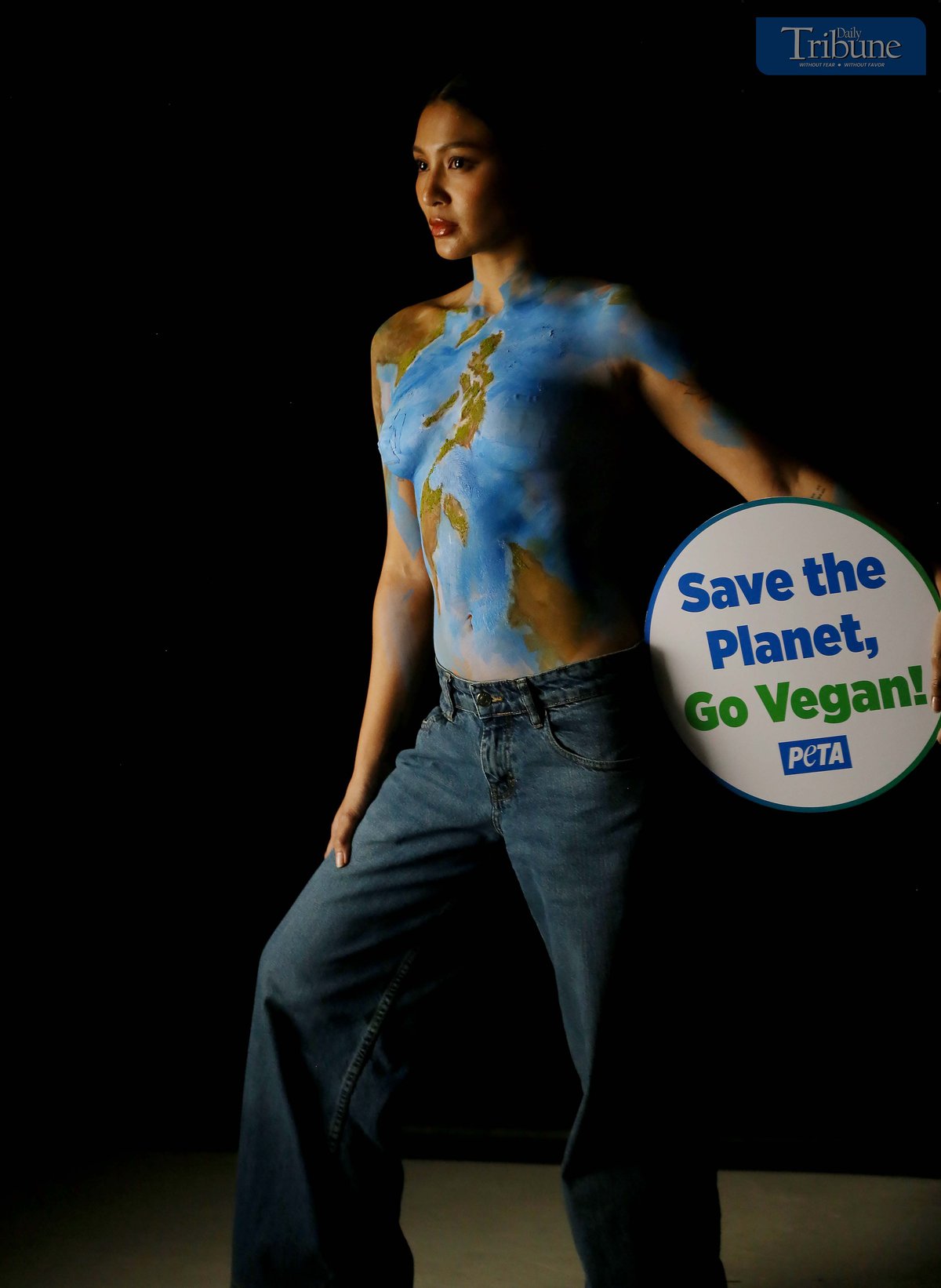 Actress and singer Nadine Lustre, wearing only body paint, holds a "Save the Planet, Go Vegan" sign while posing as Mother Earth during a photo shoot in Pasig City on 17 March  2025. Lustre promotes the vegan lifestyle as part of a campaign by People for the Ethical Treatment of Animals (PETA).