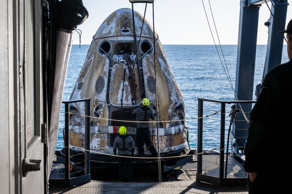 This photo provided by NASA shows support teams onboard the SpaceX recovery ship MEGAN working around a SpaceX Dragon spacecraft shortly after it landed with NASA astronauts Nick Hague, Suni Williams, Butch Wilmore, and Roscosmos cosmonaut Aleksandr Gorbunov aboard in the water off the coast of Tallahassee, Florida, 18 March 2025.