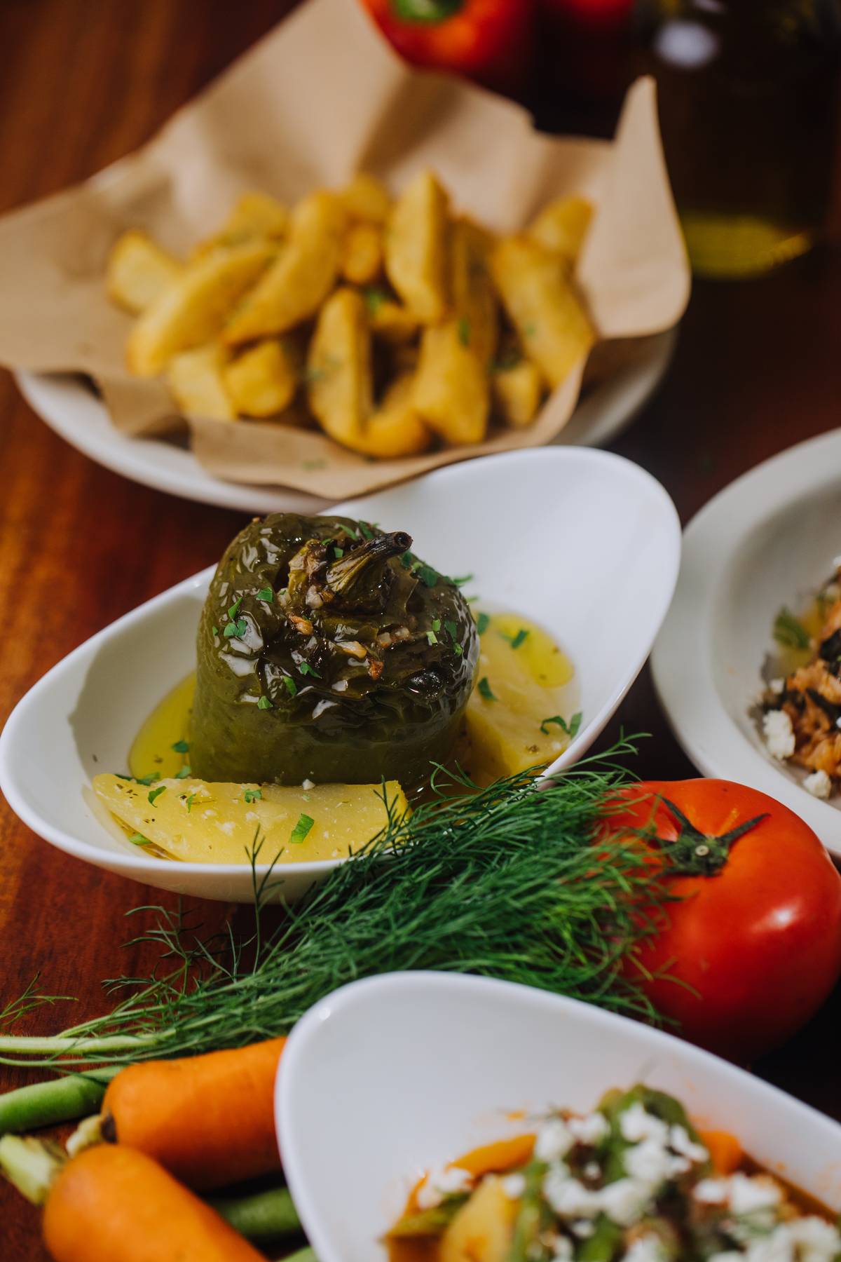 Yemista Rice-stuffed peppers with pine nuts, sultanas, and braised potatoes.