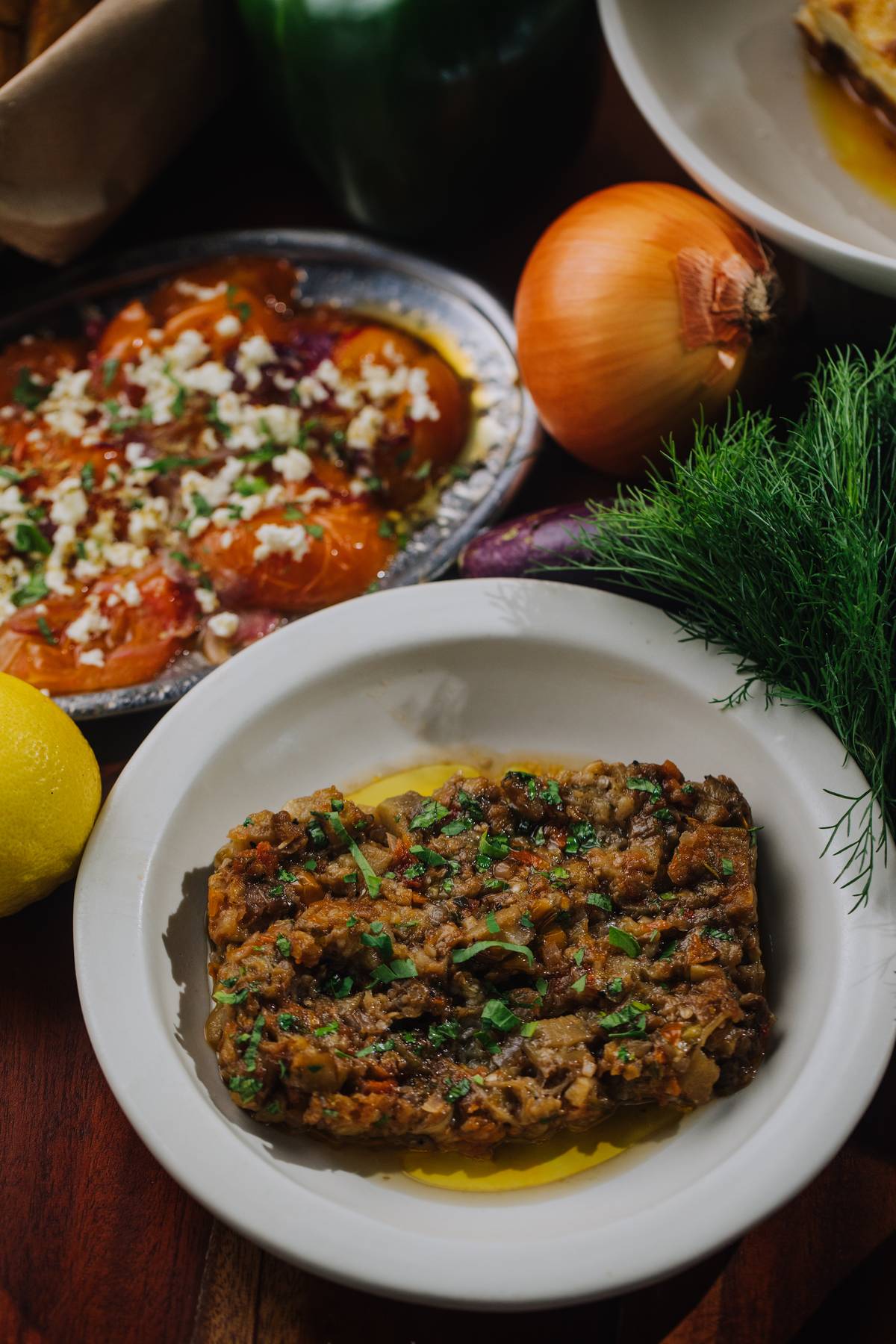 Baked Stuffed Eggplant Known as Imam Bayildi, are stuffed baked eggplant with tomato, onion, parsley.