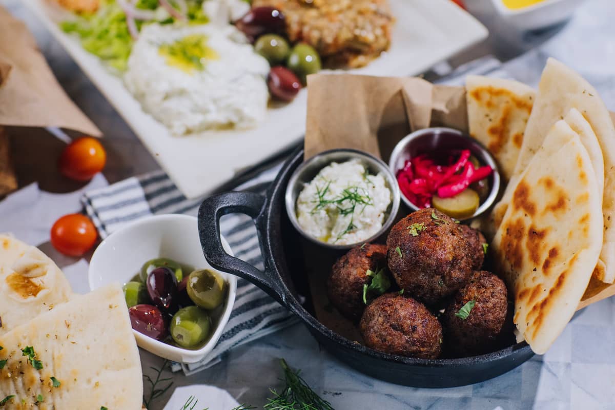 Lamb Meatballs known as Arnisio Keftedes. Lamb Meatballs served with pickles, homemade tzatziki, and lemon Salata.