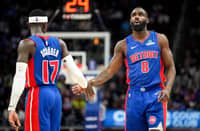 Dennis Schroder high-fives Tim Hardaway Jr. of the Detroit Pistons against the Cleveland Cavaliers