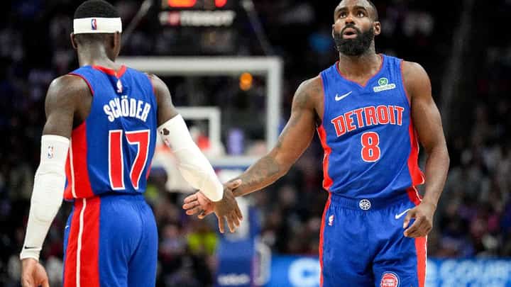 Dennis Schroder high-fives Tim Hardaway Jr. of the Detroit Pistons against the Cleveland Cavaliers
