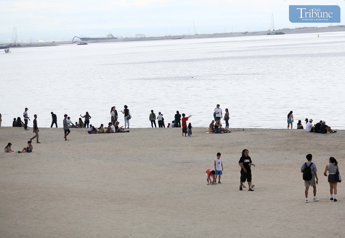 Local tourists spend time at Dolomite Beach at Manila Bay in Manila to watch the sunset on Sunday, 30 March 2025.