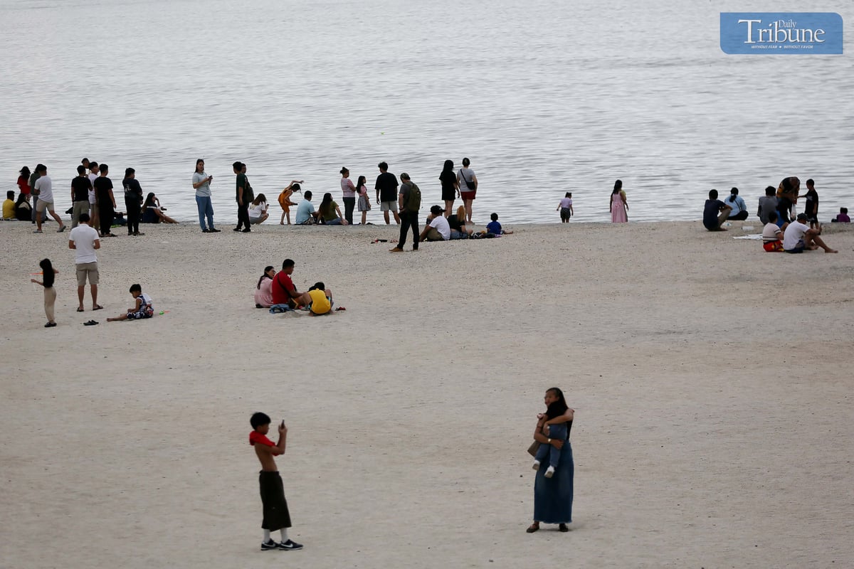 Local tourists spend time at Dolomite Beach at Manila Bay in Manila to watch the sunset on Sunday, 30 March 2025.