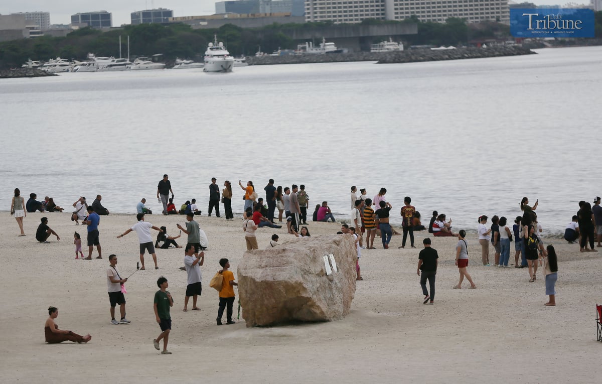 Local tourists spend time at Dolomite Beach at Manila Bay in Manila to watch the sunset on Sunday, 30 March 2025.