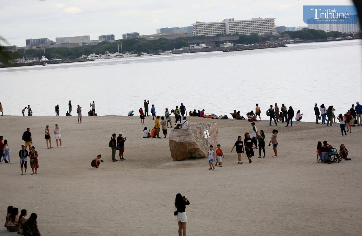 Local tourists spend time at Dolomite Beach at Manila Bay in Manila to watch the sunset on Sunday, 30 March 2025.