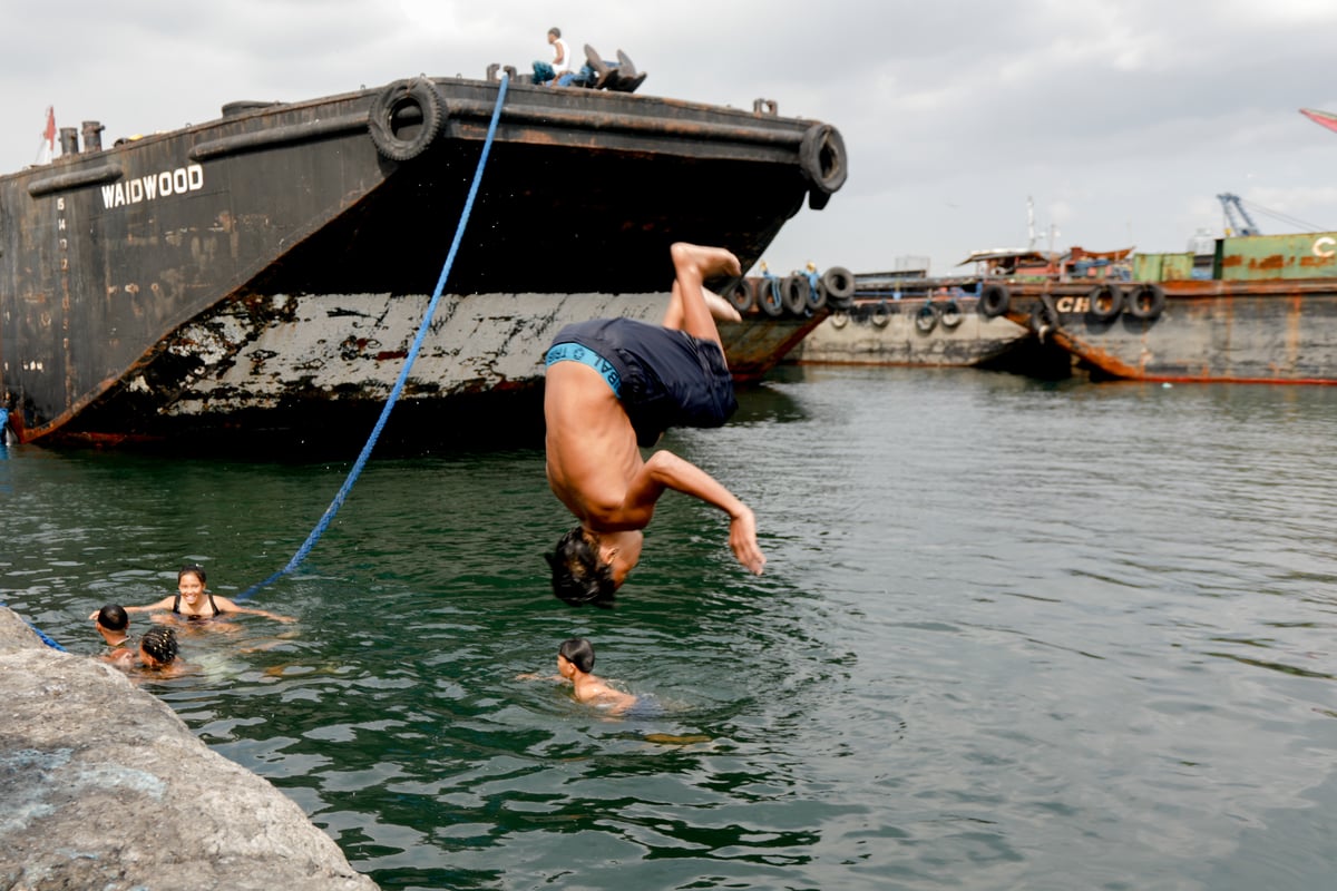 A young diver performs a frontflip during his afternoon dip at Manila Bay in Baseco Port.