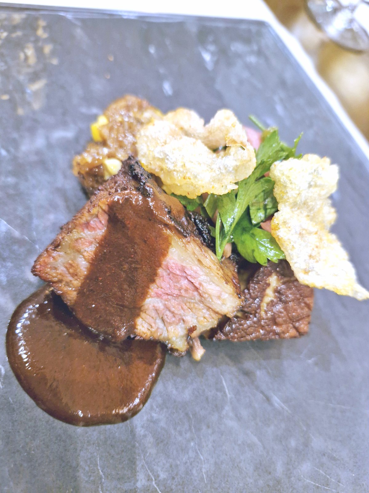 Beef short rib ‘al pastor’ with a Filipino adobo sauce and a collection of fusion-forward accompaniments.