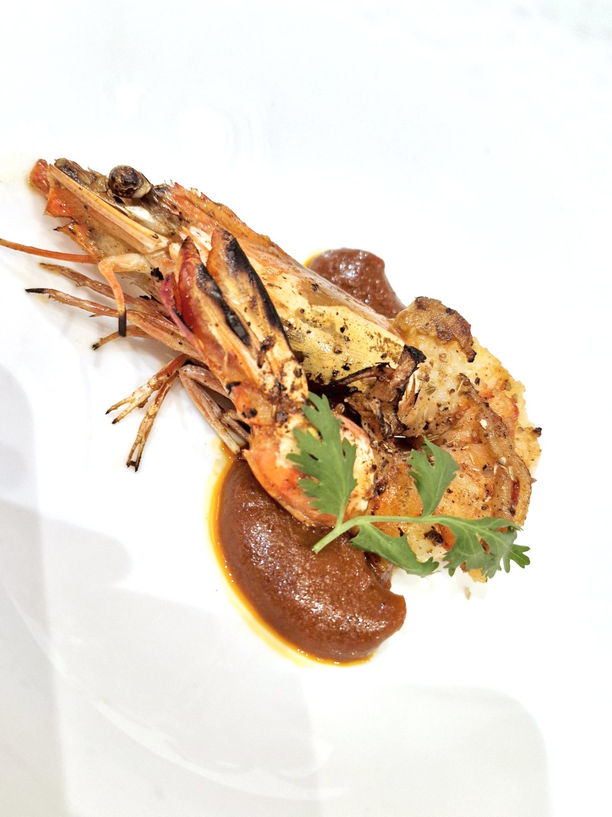 Black pepper and coriander king prawn on plantain mole.