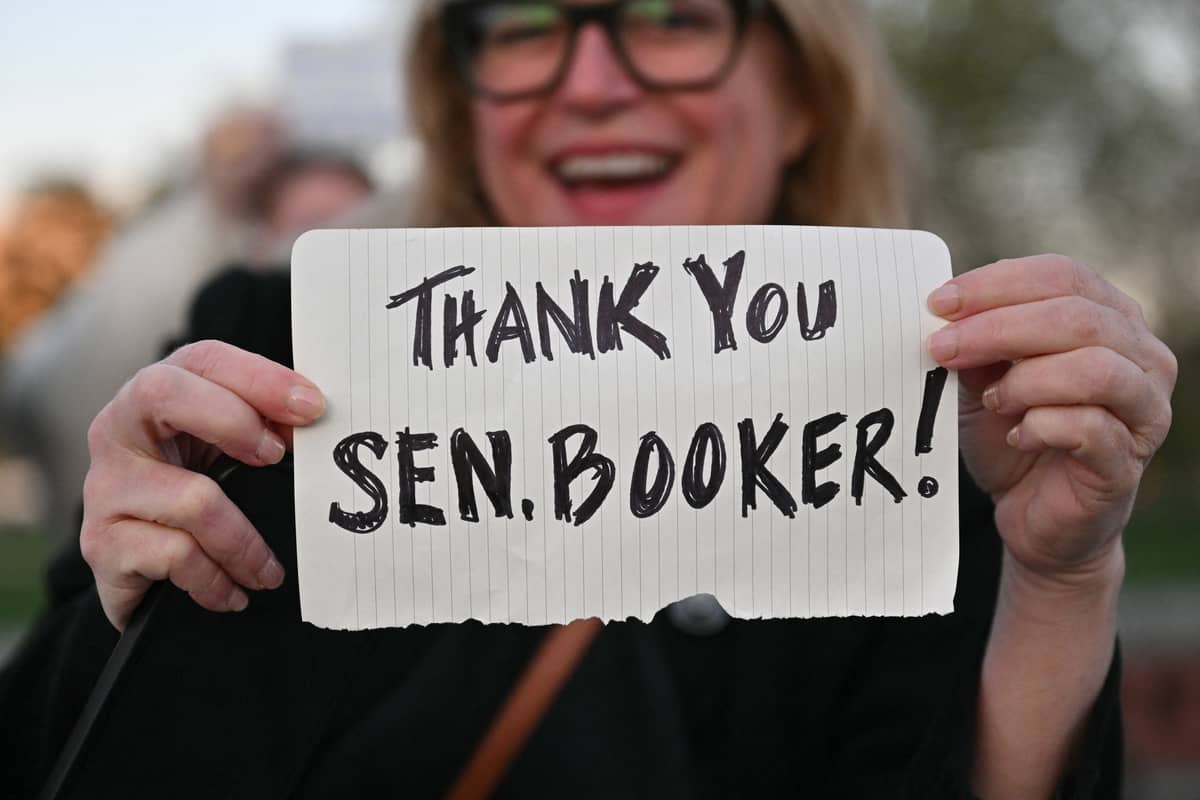 A person holds a sign as supporters of US Senator Cory Booker (D-NJ) gather outside the US Capitol as he speaks on the Senate floor in Washington, DC, on 1 April 2025. Democrat Cory Booker on 1 April set a record for the longest speech in Senate history after speaking for more than 24 hours, a dramatic gesture highlighting what he said is President Donald Trump's threat to US democracy.