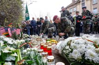 German and other NATO soldiers lay flowers and light candles outside the US Embassy in Vilnius, Lithuania, on 1 April 2025, to honor the four US soldiers who died during a military drill at the Pabrade training ground. All four soldiers, who had been missing since last week, have now been confirmed dead after rescuers recovered their armored vehicle from a swamp.