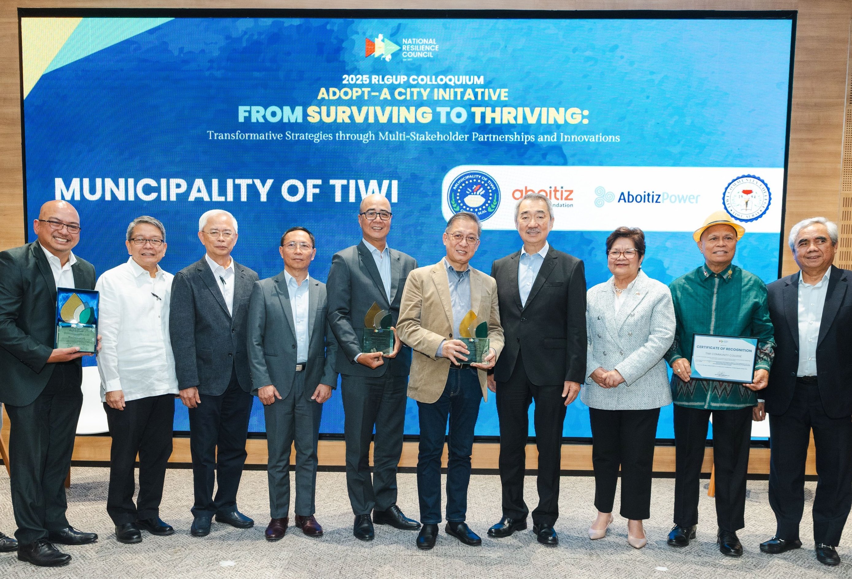 AP Renewables Inc. president and COO Jeffrey Estrella (5th from left), and Tiwi Mayor Jaime Villanueva (5th from right), with their plaques of recognition from National Resilience Council (NRC), led by its president and chairman Hans Sy (4th from right), during an NRC conference in Pasay City. With them is DENR Undersecretary Marilou G. Erni (3rd from right).