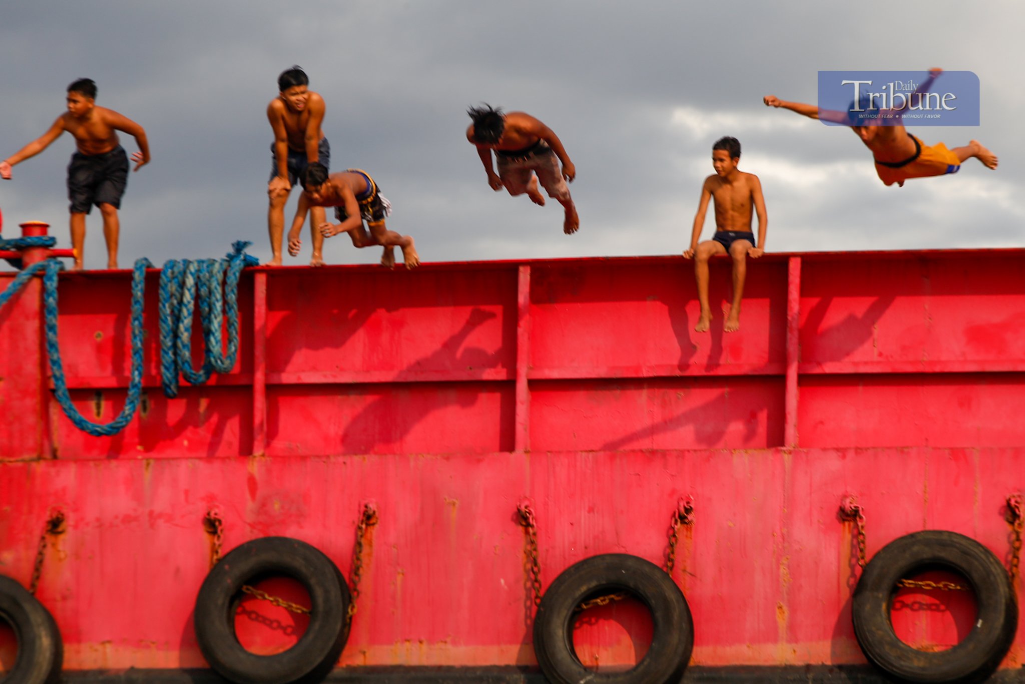 Residents of Baseco beat the heat by jumping off a barge moored at the seawall in Tondo, Manila.