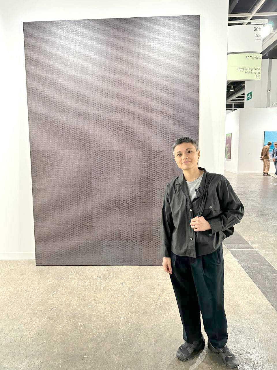 Maria Taniguchi with her painting at the booth of ROH Projects.