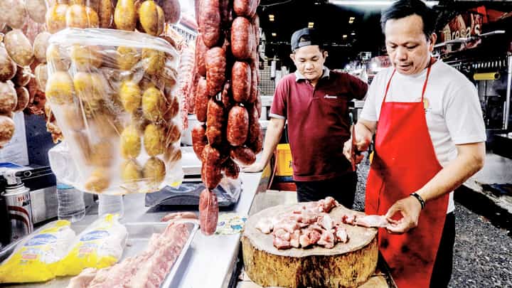 A meat vendor chops pork purchased by a customer inside a market in Quezon City on Wednesday.