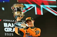 McLaren's Australian driver Oscar Piastri lifts the trophy on podium after winning the Bahrain Formula One Grand Prix at the Bahrain International Circuit in Sakhir on April 13, 2025.