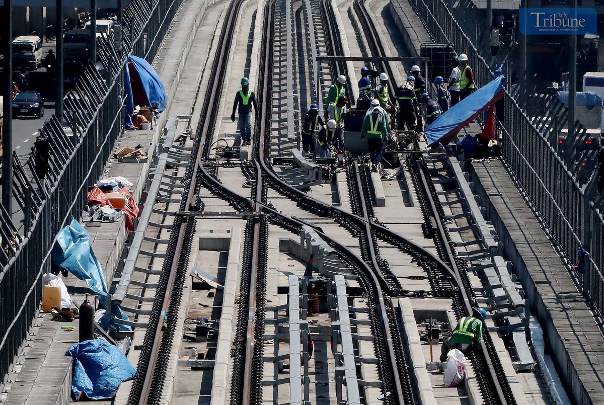 Workers toil under the scorching sun along Commonwealth Avenue in Quezon City as construction on the Metro Rail Transit Line 7 (MRT-7) continues on Monday, March 2025. As of Monday, the National Economic and Development Authority says the project is 78.63% complete. Partial operations are targeted for 2026, with full operations expected by 2027.