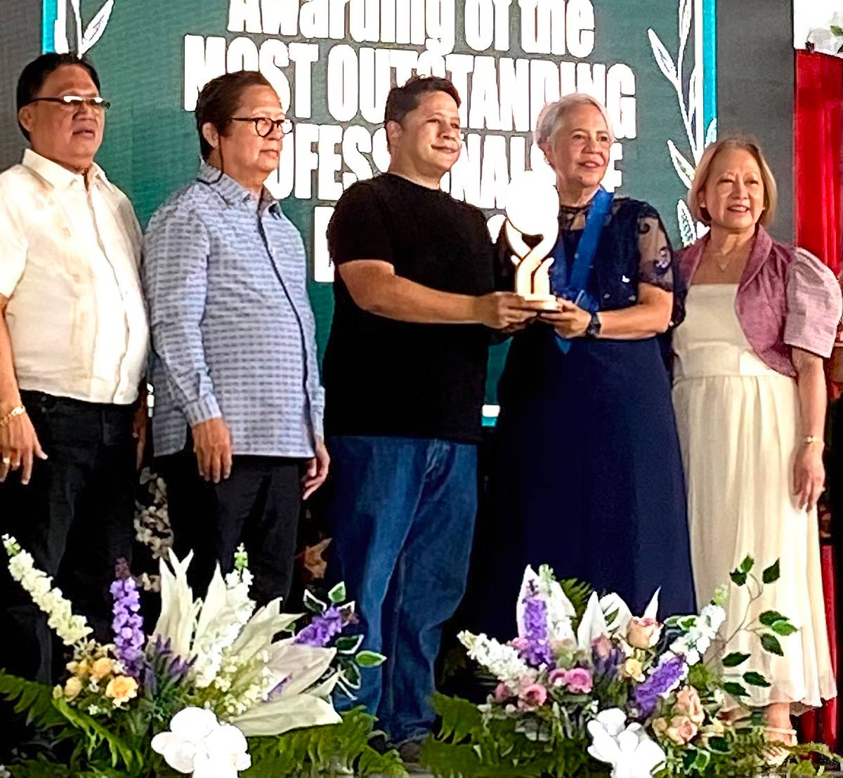 Patricia de Peralta Quiason (second from right) and Raoul de Peralta hold the trophy presented to Dr. Rizal Guerrero de Peralta as 2025 Most Outstanding Professional of Dingras (posthumous) by the International Professional Association of Dingras. Looking on, from left, are Dingras Vice Mayor Erdio Valenzuela,  IPAD president Reynaldo L. Saludares and IPAD chairman Marilyn Baquiran.