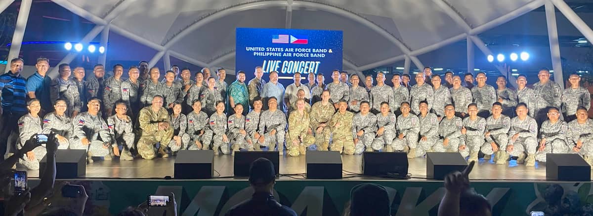 Right: Musicians and officers of the U.S. Air Force Band of the Pacific and the Philippine Air Force Band pose onstage with representatives from the U.S. Embassy after the joint live performance at the SM Mall of Asia Sky Amphitheater on 6 April.