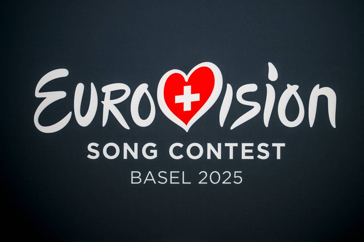 Logo of the Eurovision Song Contest 2025 featuring stylized white text with a red heart containing a Swiss cross, set against a dark background with “Basel 2025” written below.