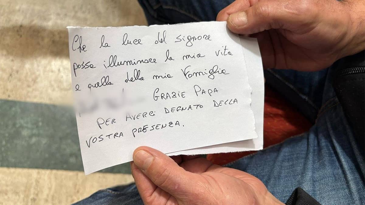 Close-up of a handwritten note in Italian by an inmate, thanking Pope Francis for visiting Regina Coeli Prison and praying for his family.