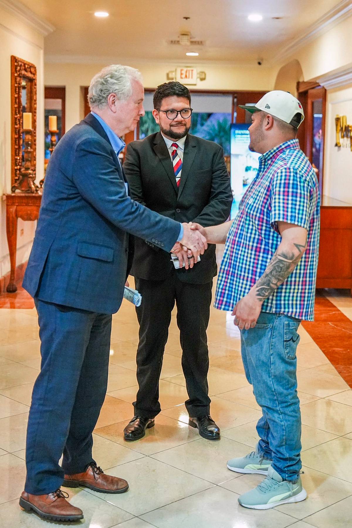 US Senator Chris Van Hollen shakes hands with Kilmar Abrego Garcia, a Salvadoran migrant wrongfully deported from the US, during a meeting in San Salvador on 17 April 2025. Another official stands nearby.