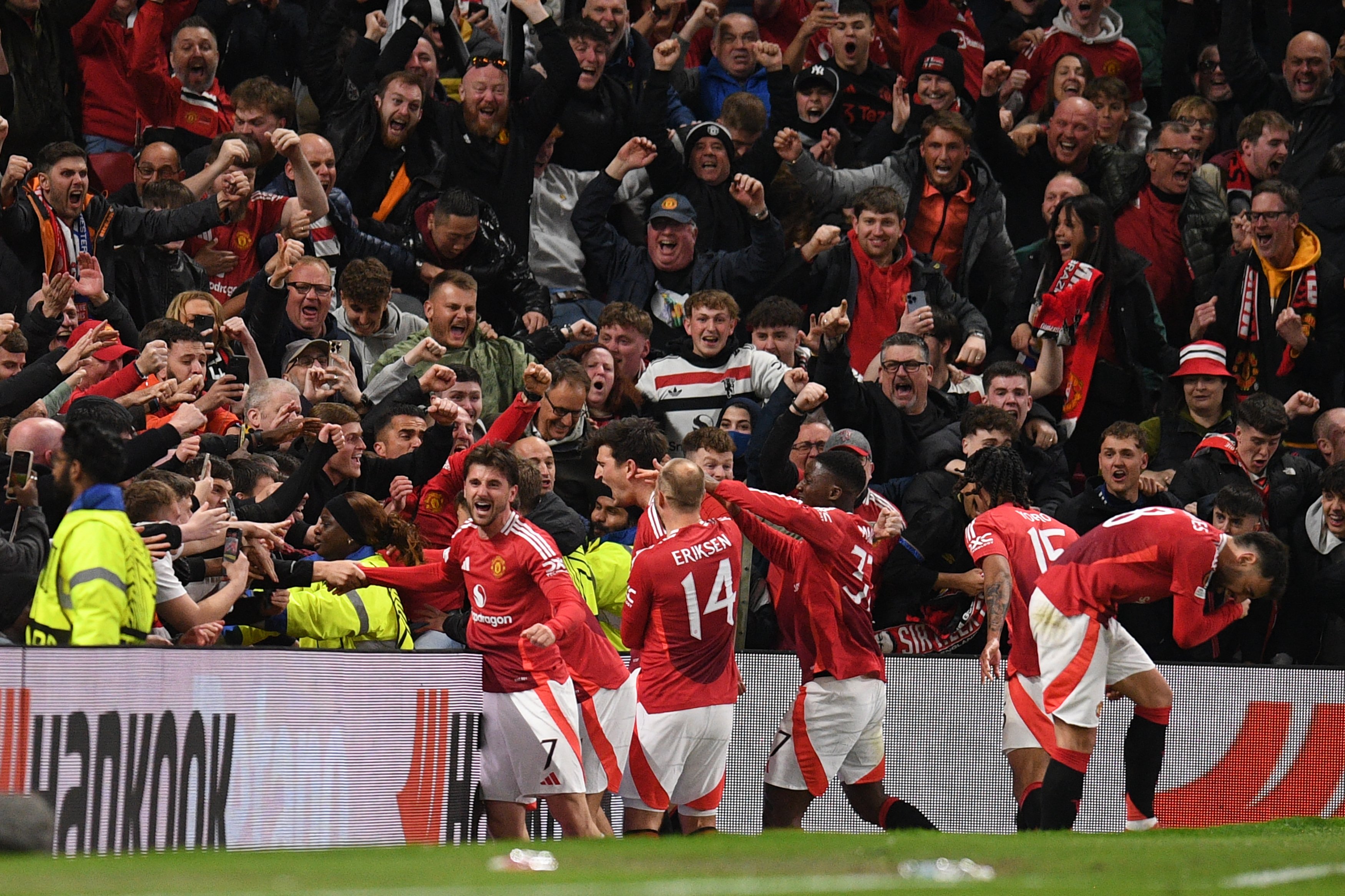 Manchester United's English defender #05 Harry Maguire and teammates celebrate with their fans after Maguire scores their fifth goal during the UEFA Europa league quarter-final final, second leg football match between Manchester United and Lyon at Old Trafford stadium in Manchester, north west England, on 17 April 2025.