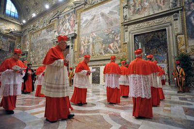 Catholic cardinals dressed in red vestments walk solemnly through a fresco-lined corridor toward the Sistine Chapel as they prepare to enter the papal conclave.