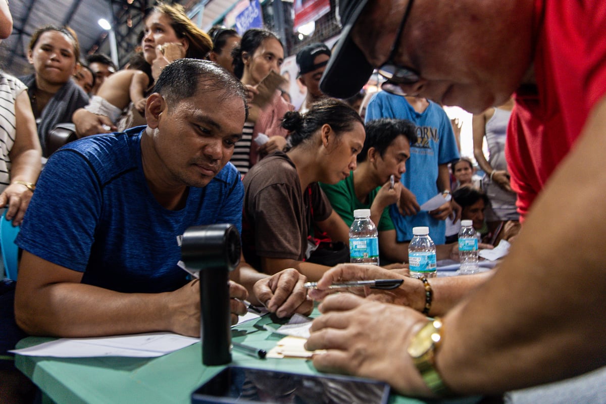 Residents receive aid from the Manila local government soon after they get displaced by the massive fire. A nearby covered court is jump packed with evacuees lining up to receive financial support from local authorities.