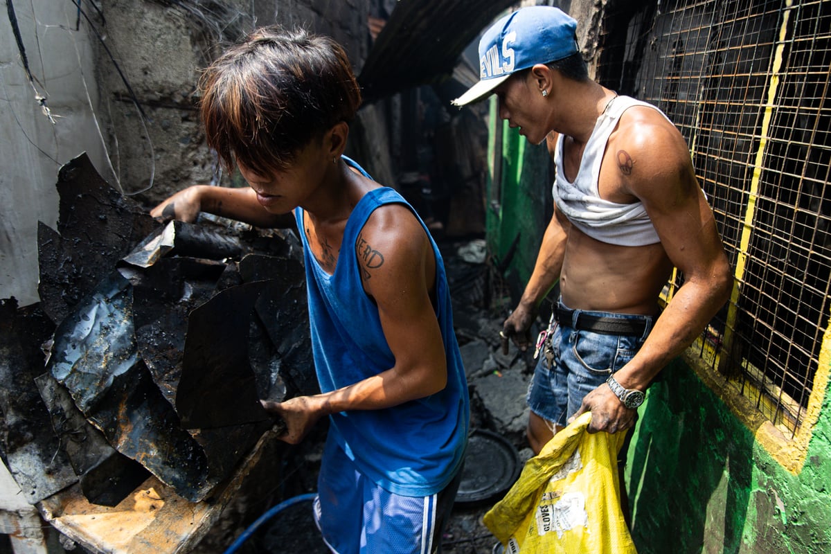Residents don't mind the heat as they continue to pick up scraps, hoping to sell them and earn money while recovering from the blaze that left them homeless.