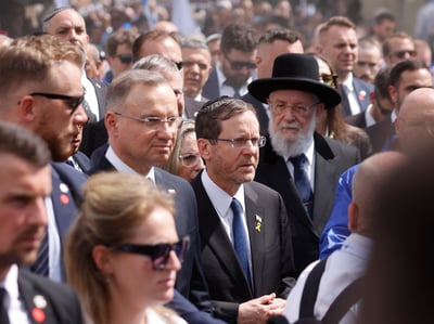 Polish President Andrzej Duda and Israeli President Isaac Herzog walk among a solemn crowd at the Auschwitz-Birkenau Memorial during the 2025 March of the Living, commemorating Holocaust victims and the 80th anniversary of WWII’s end.
