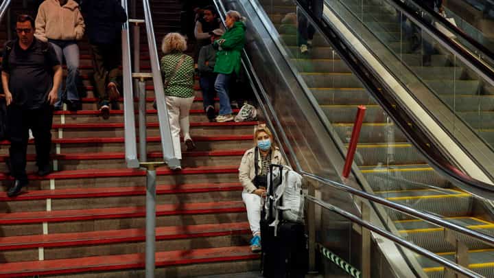 A traveler sits on the stairs as she prepares to spend the night at the Atocha train station, following a massive power cut affecting the entire Iberian peninsula and the south of France, in Madrid on 28 April 2025.