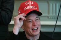Elon Musk, wearing two hats, speaks during a cabinet meeting in the Cabinet Room of the White House in Washington, DC, on 30 April 2025.
