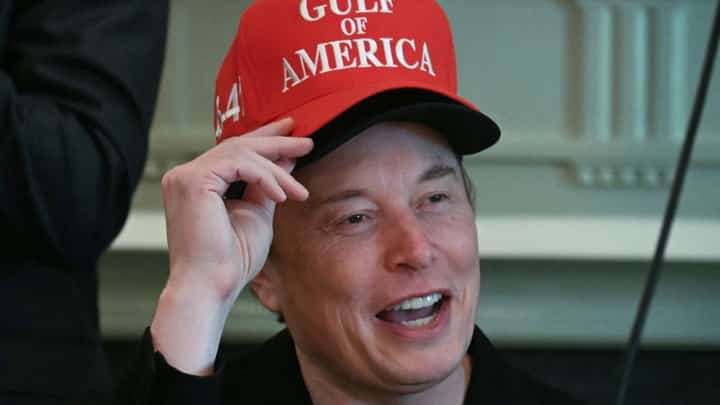 Elon Musk, wearing two hats, speaks during a cabinet meeting in the Cabinet Room of the White House in Washington, DC, on 30 April 2025.