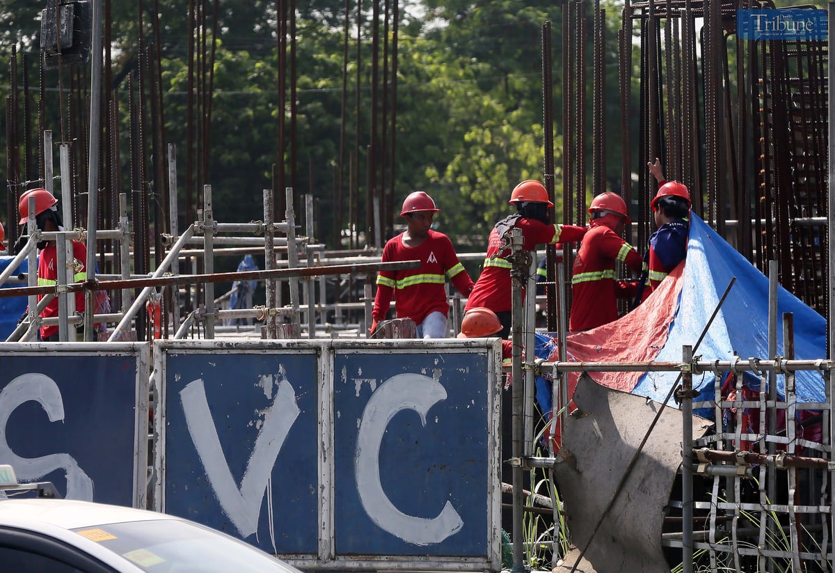 Construction workers at the Metro Rail Transit (MRT-7) site along Commonwealth Avenue in Quezon City work on Wednesday, ahead of the Labor Day celebration.